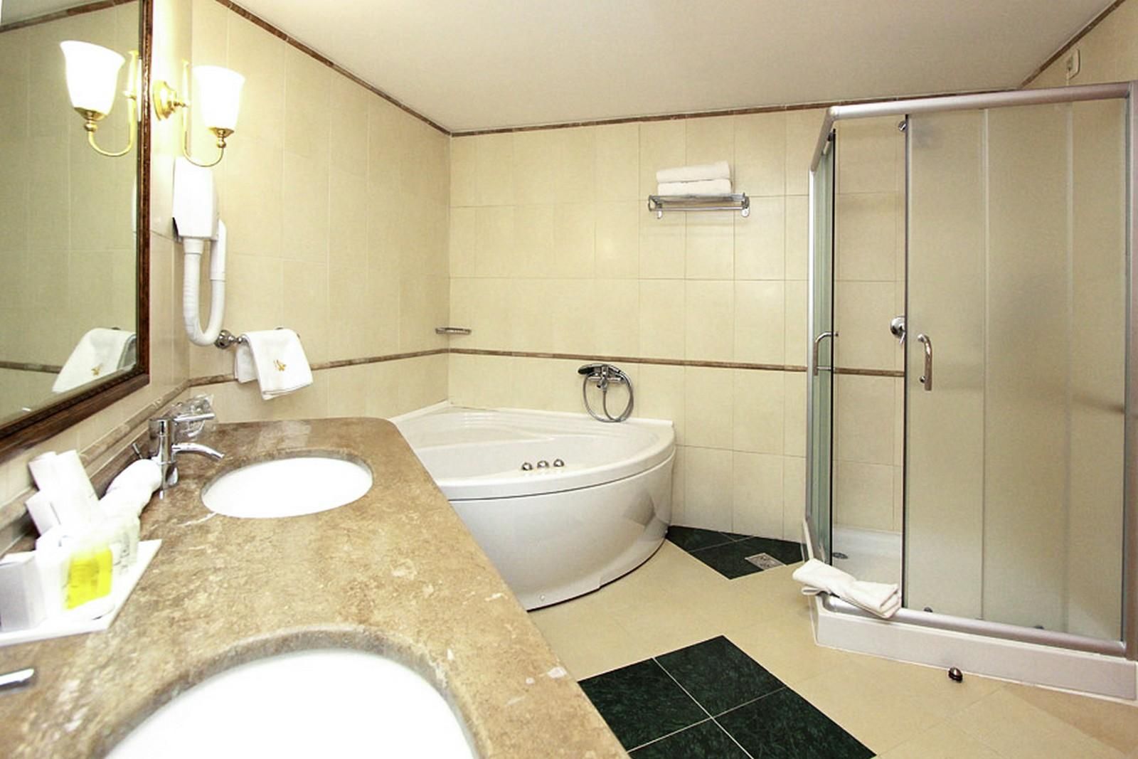 Hotel Izvor - kupatilo sa tuš kabinom i kadom.png