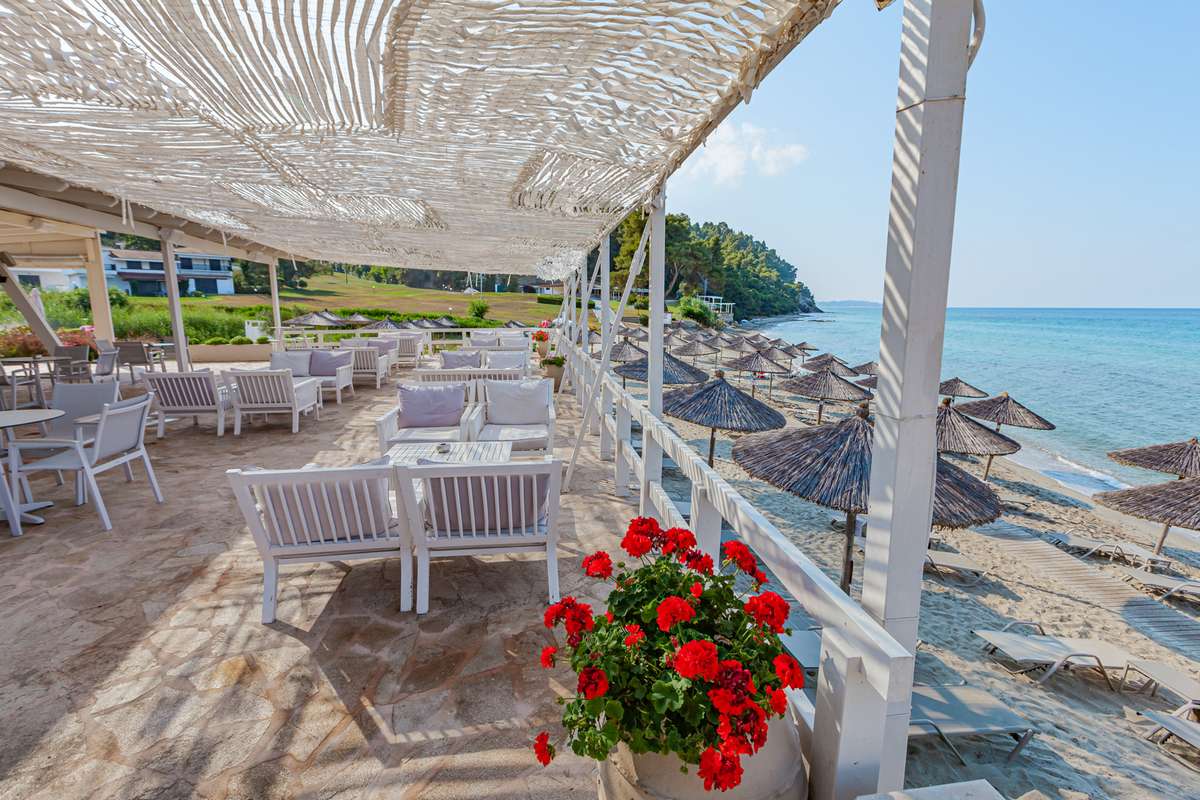 Hotel Elani Bay Resort - stolovi i stolice pored mora.jpg