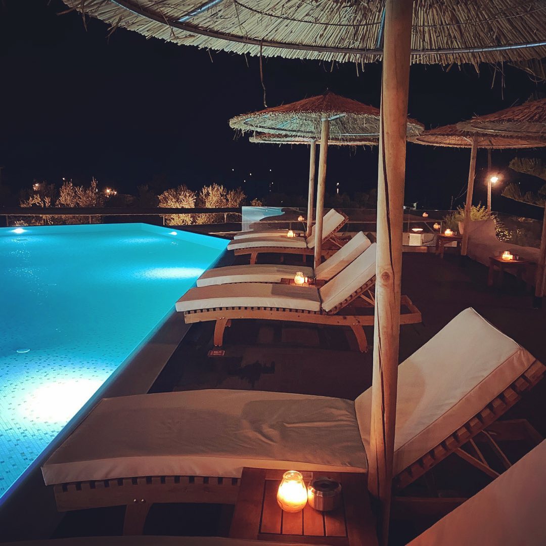 Panormos Beach - lezaljke pored bazena nocu.jpg