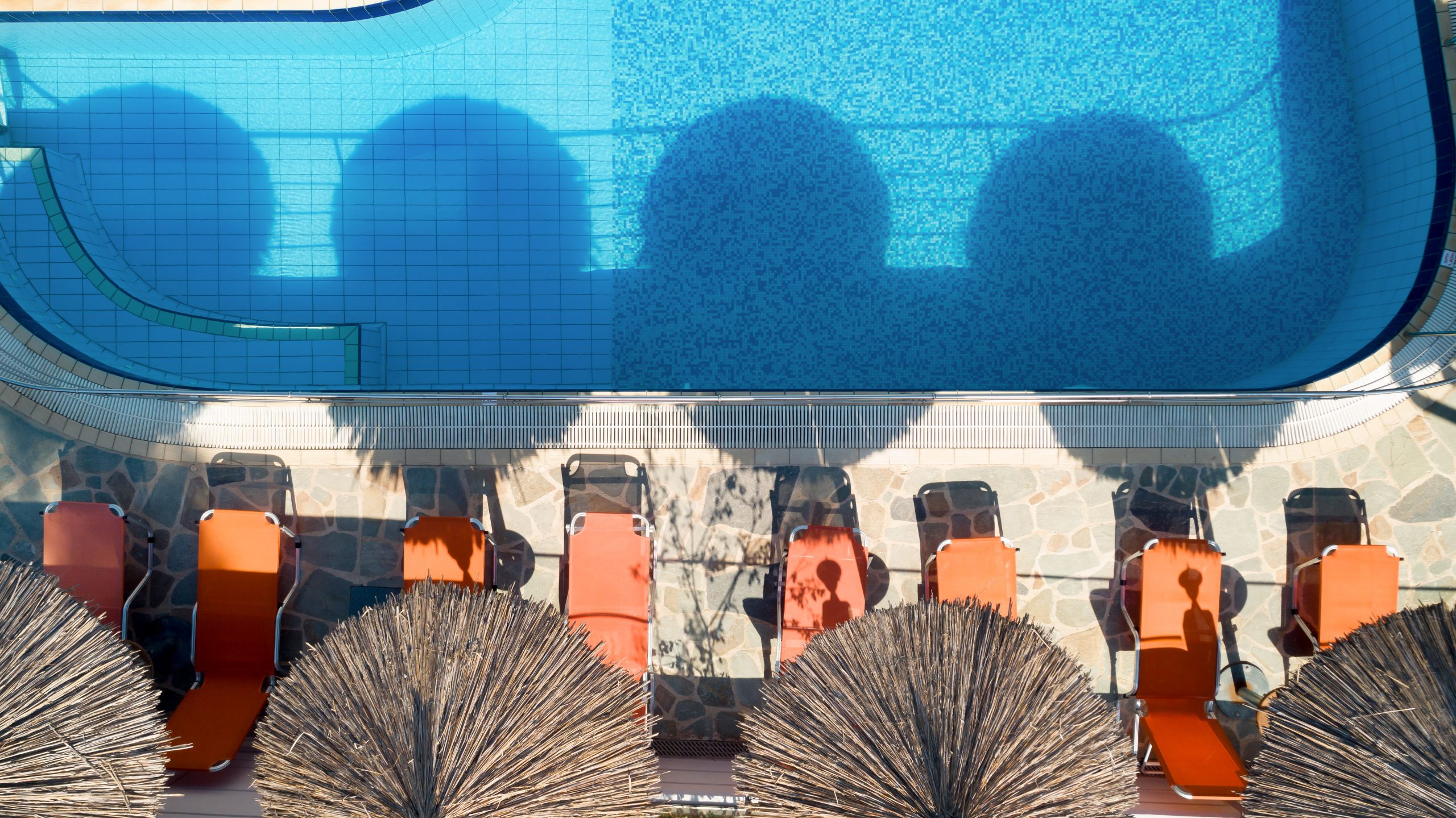 Sirines Hotel - ležaljke i suncobrani pored bazena.jpg