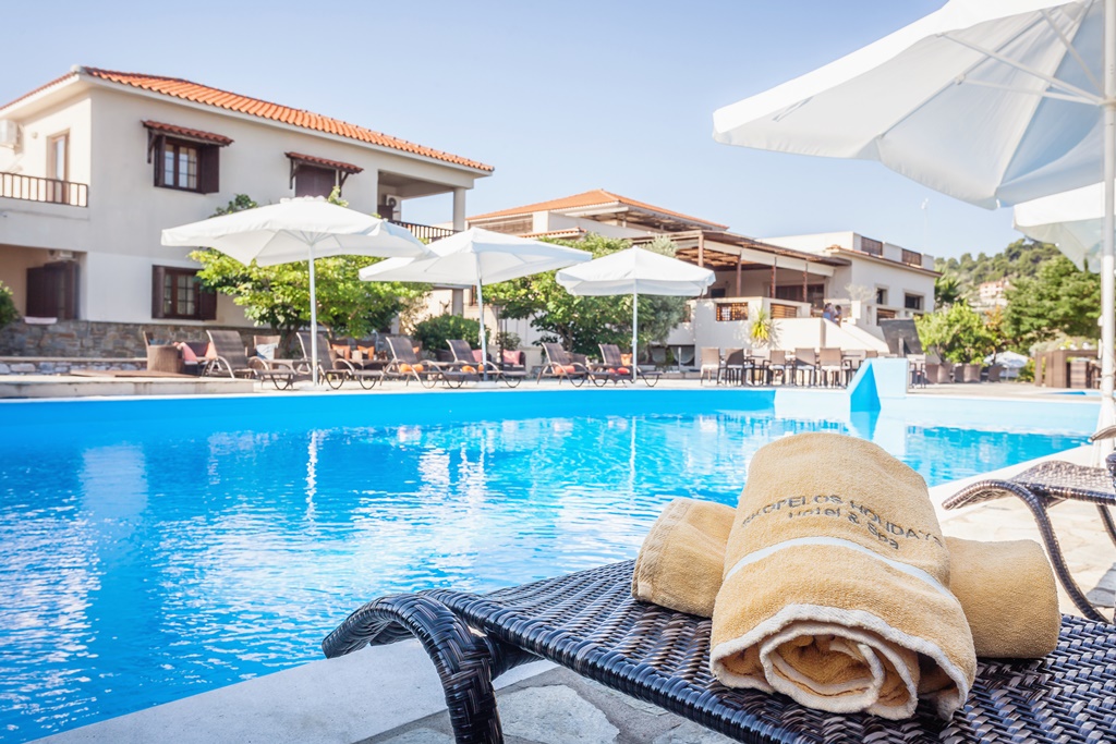 Skopelos Holidays Hotel _ Spa - lezaljke i suncobrani pored bazena.jpg