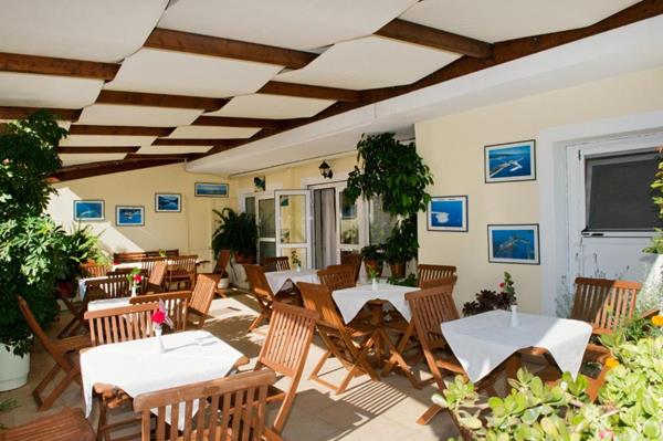 Vassiliki Bay - stolovi i stolice restorana na terasi.jpg